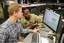 Soldier and civilian at computer