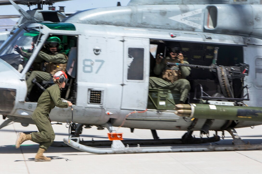 Marines prepare a UH-1Y Venom helicopter for takeoff.