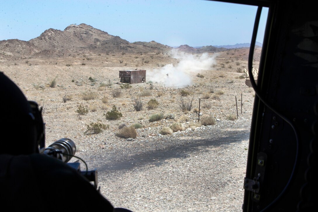 A Marine fires a mini-gun.