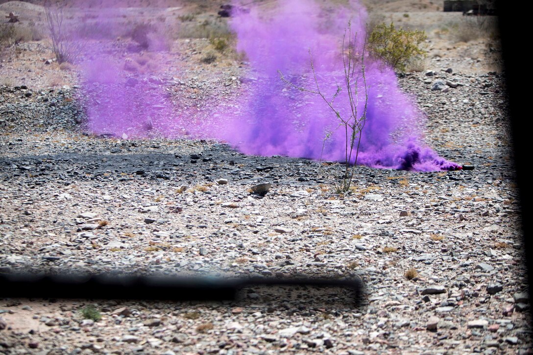 Marines use smoke grenades to mark a munitions reloading site.