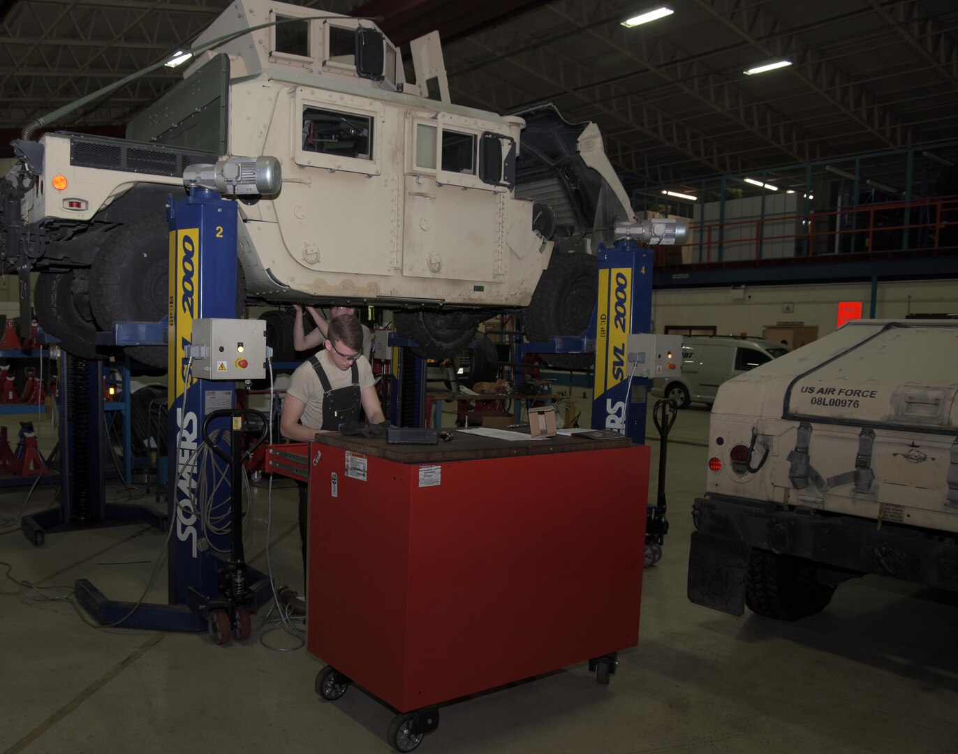 U.S. Air Force Airman 1st Class Joshua Patterson, 100th Logistics Readiness Squadron mission generating vehicular maintenance journeyman, picks a tool to help with modifications to a Humvee at RAF Mildenhall, England, Jan. 29, 2018.  The goal and job of vehicle maintenance is to maintain the Wing’s fleet of vehicles. (U.S. Air Force photo by Airman 1st Class Benjamin Cooper)