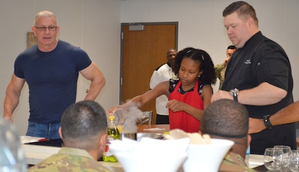 Taylor Flagg (center) assists chef's Robert Irvine and Shane Cash during a cooking demonstration at the teaching kitchen in the new Vogel Resiliency Center April 5 at Joint Base San Antonio-Fort Sam Houston. Irvine was in San Antonio with actor, director and musician Gary Sinise for the Invincible Spirit Festival at Brooke Army Medical Center.