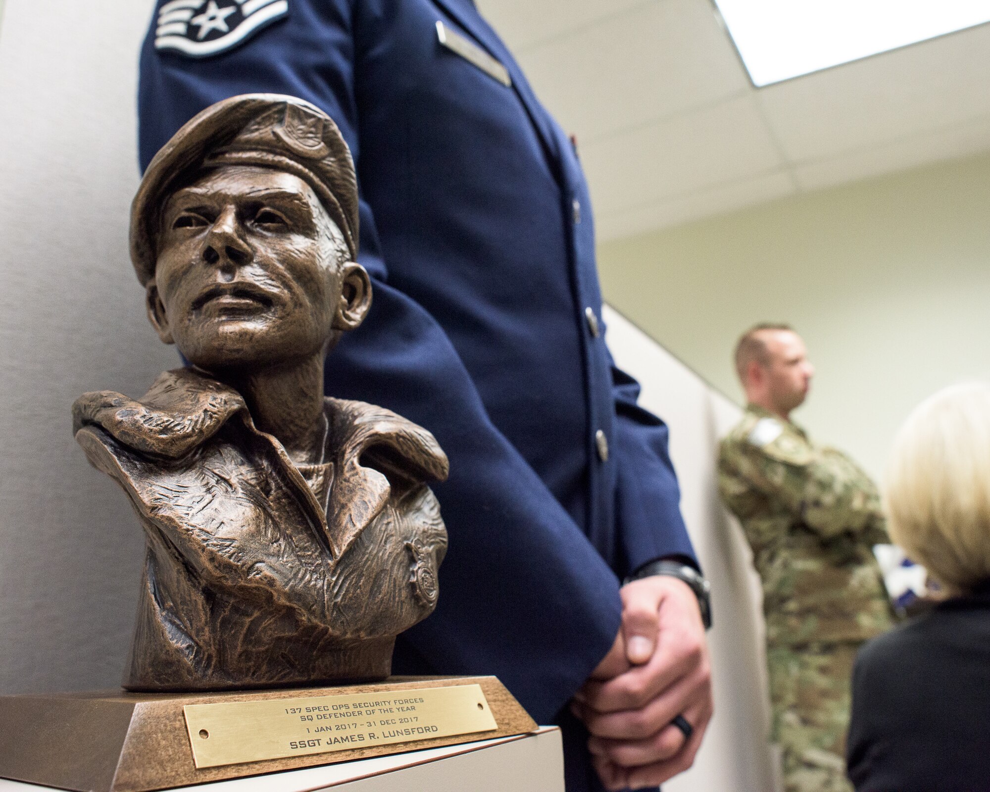 U.S. Air Force Staff Sgt. James Lunsford, 137th Special Operations Security Forces Squadron, stands beside the La Don Johnson award after receiving the honor at Will Rogers Air National Guard Base, Feb. 3, 2018. The La Don Johnson award is given by fellow security forces airmen for continued excellence during everyday duties. (U.S. Air National Guard photo by Tech. Sgt. Caroline Essex)