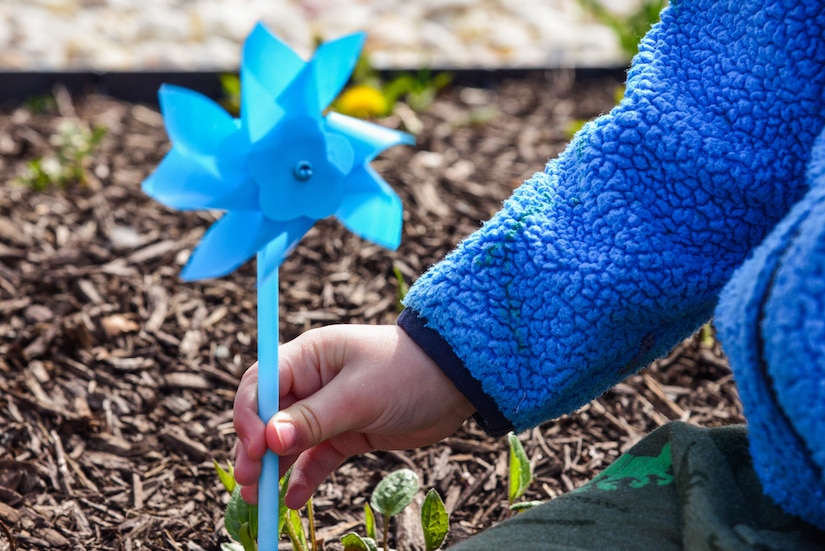 A child plants a pinwheel at the Russ Child Development Center annex at Joint Base Langley-Eustis, Va., April 2, 2018.)