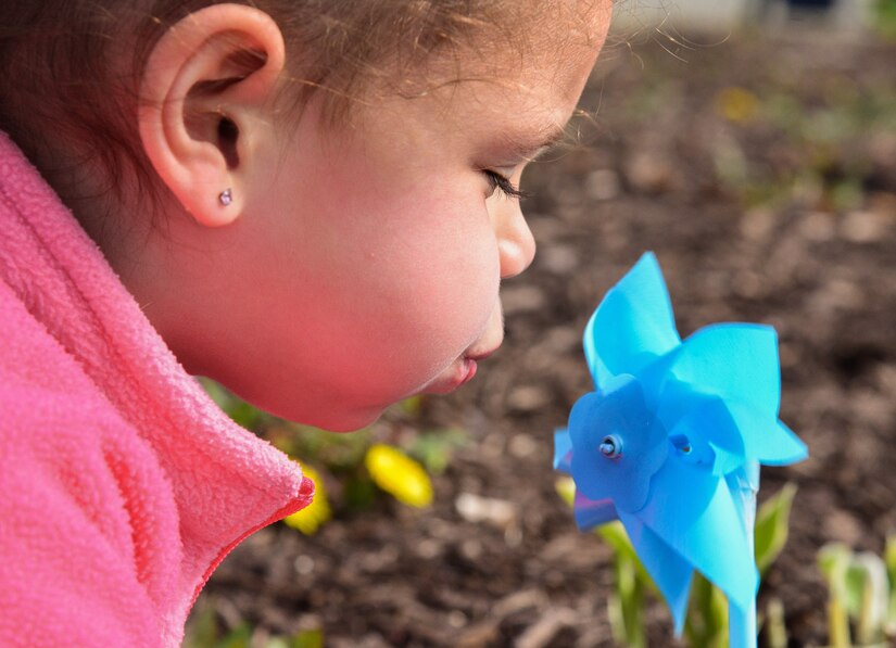 Madison Rauch, age 4, daughter of Kasana Rauch, 480th Intelligence Reconnaissance Readiness squadron contractor, plays with a planted pinwheel at the Russ Child Development Center annex at Joint Base Langley-Eustis, Va., April 2, 2018.
