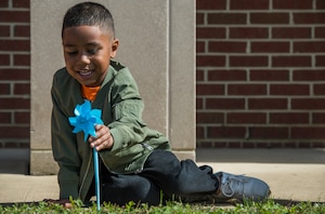 Jordan Milana, age 4, son of U.S. Navy Petty Officer 3rd Class Monique Smith, Naval Portsmouth Hospital aviation boatswain's mate, plants a pinwheel at the Russ Child Development Center annex at Joint Base Langley-Eustis, Va., April 2, 2018.