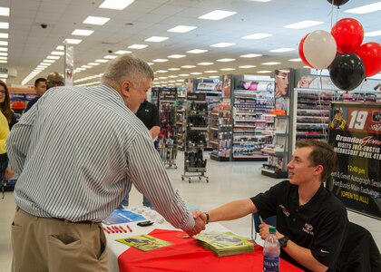 NASCAR driver Brandon Jones shakes hands with Matt Goldem, U.S. Army Training Support Center training specialist, in the Fort Eustis Exchange at Joint Base Langley-Eustis, Virginia, April 4, 2018. Jones signed autographs and took pictures with fans before his base tour came to an end. (U.S. Air Force photo by Airman 1st Class Monica Roybal)
