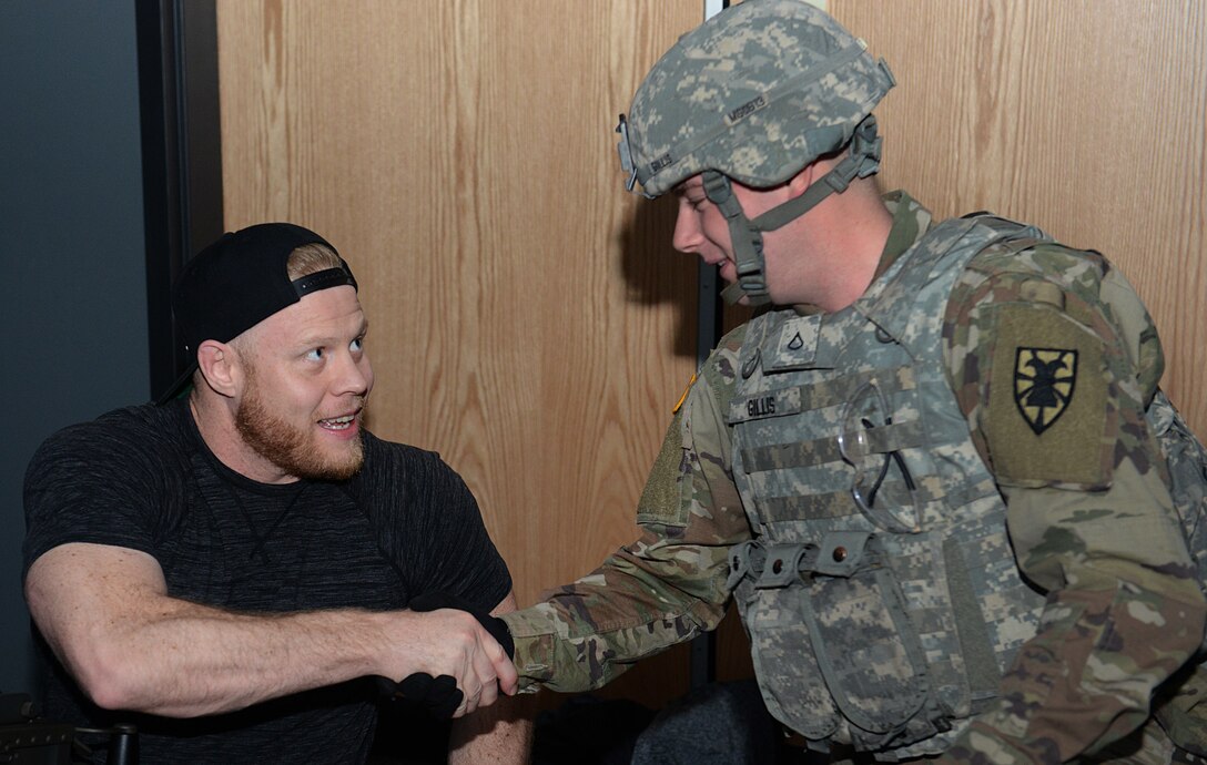 Eric Nicksick, Mixed Martial Arts coach and trainer, shakes hands with a U.S. Army Soldier during a tour at Joint Base Langley-Eustis, Va., April 5, 2018.