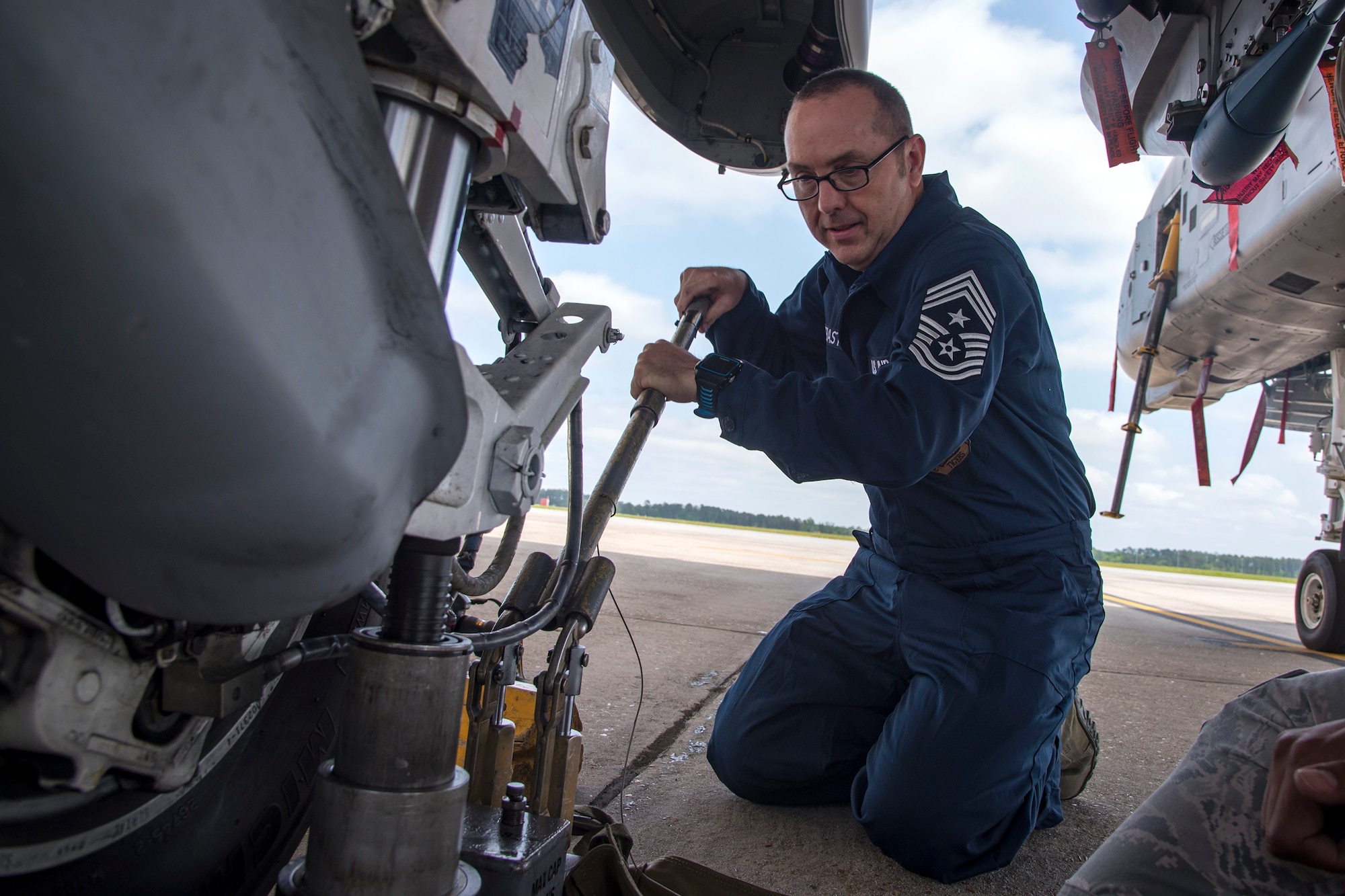 Chief Master Sgt. Jarrod Sebastian, 23d Wing command chief, pushes down on a tire jack during an immersion tour, April 9, 2018, at Moody Air Force Base, Ga. Moody’s leadership toured the 23d Aircraft Maintenance Squadron to get a better understanding of their overall mission, capabilities, and comprehensive duties. (U.S. Air Force photo by Airman Eugene Oliver)