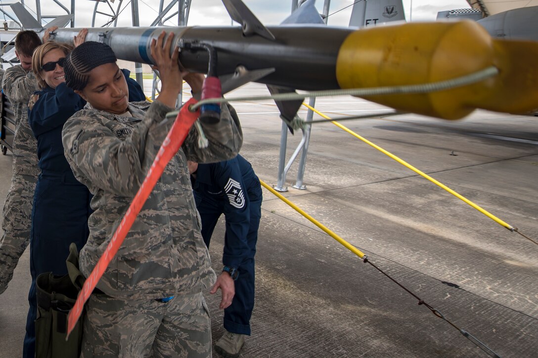 Col. Jennifer Short, middle, 23d Wing commander, and Airmen from the 23d Aircraft Maintenance Squadron (AMXS) carry an AIM-9 air to air missile during an immersion tour, April 9, 2018, at Moody Air Force Base, Ga. Moody’s leadership toured the 23d AMXS to get a better understanding of their overall mission, capabilities, and comprehensive duties. (U.S. Air Force photo by Airman Eugene Oliver)