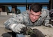 U.S. Air Force Airman 1st Class Anthony Rouleau, 633rd Civil Engineer Squadron readiness and emergency flight member, removes rocks from the curb inlet during a Filterra Stormwater Bioretention maintenance at Joint Base Langley-Eustis, Va., April 5, 2018.