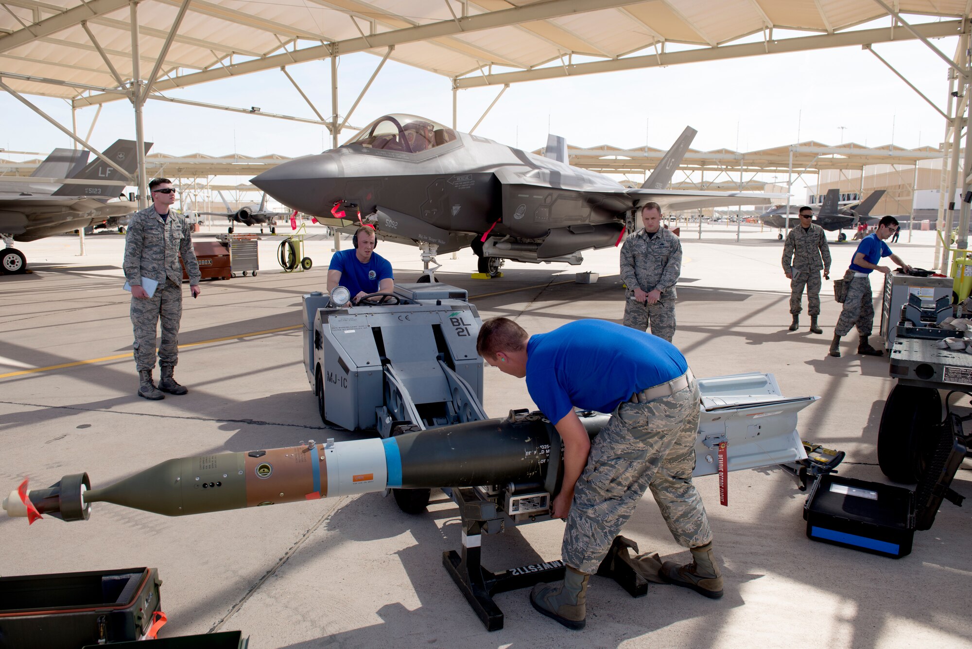 Judges observe as a weapons load crew from the 62nd Aircraft Maintenance Unit prepares an inert bomb for loading during the 2018 1st Quarter Load Crew Competition at Luke Air Force Base, Ariz., April 6. The 62nd AMU team beat five other teams to win the competition. (U.S. Air Force photo by Senior Airman Ridge Shan)