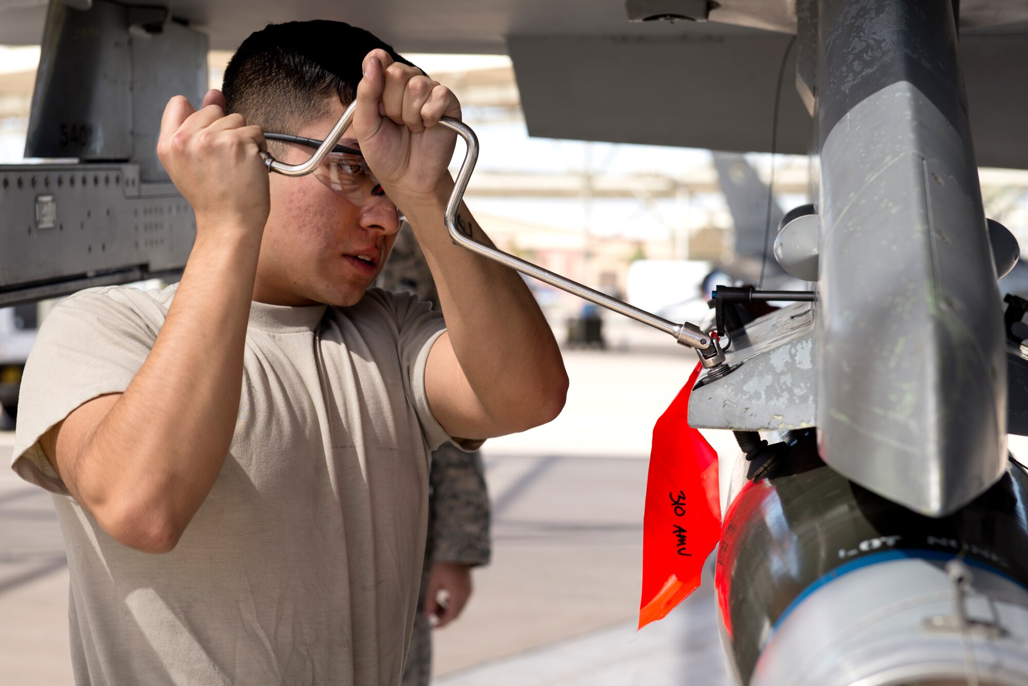 Airman Michael Gutierrez, 310th Aircraft Maintenance Unit weapons load crew member, attaches an inert bomb to an F-16 Fighting Falcon during the 2018 1st Quarter Load Crew Competition at Luke Air Force Base, Ariz., April 6. Teams of three load crew members used teamwork, communication, and technical knowledge to race to load weapons onto fighter aircraft under the watchful eye of experienced judges. (U.S. Air Force photo by Senior Airman Ridge Shan)