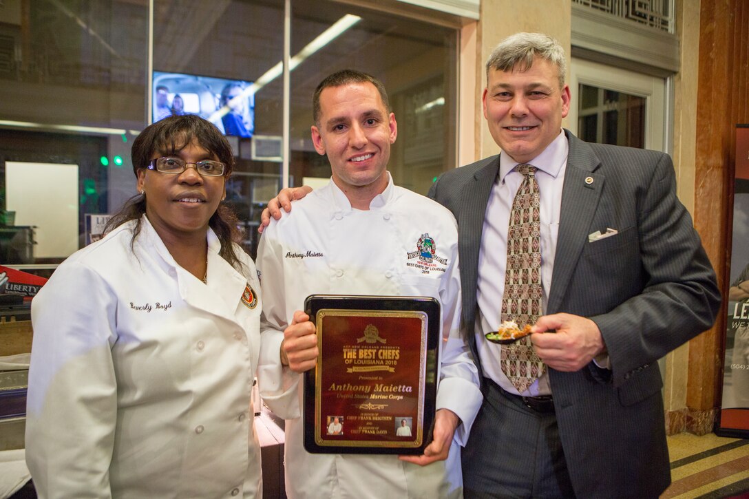(left to right) Beverly Boyd, protocol officer for Marine Forces Reserve, Staff Sgt. Anthony Maietta, an enlisted aide to Lt. Gen. Rex C. McMillian, commander of MARFORRES and Marine Forces North, and Gregg Habel, executive director for MARFORRES and MARFORNORTH, pose for a photo during the annual Best Chef Louisiana competition at the Lakefront Airport Terminal Building, New Orleans, April 10, 2018. The chefs event gives recognition to select chefs and honors them for their contribution to the New Orleans culinary scene and is also an opportunity for them to showcase their talent by serving a sampling of their signature dishes to the attendees.