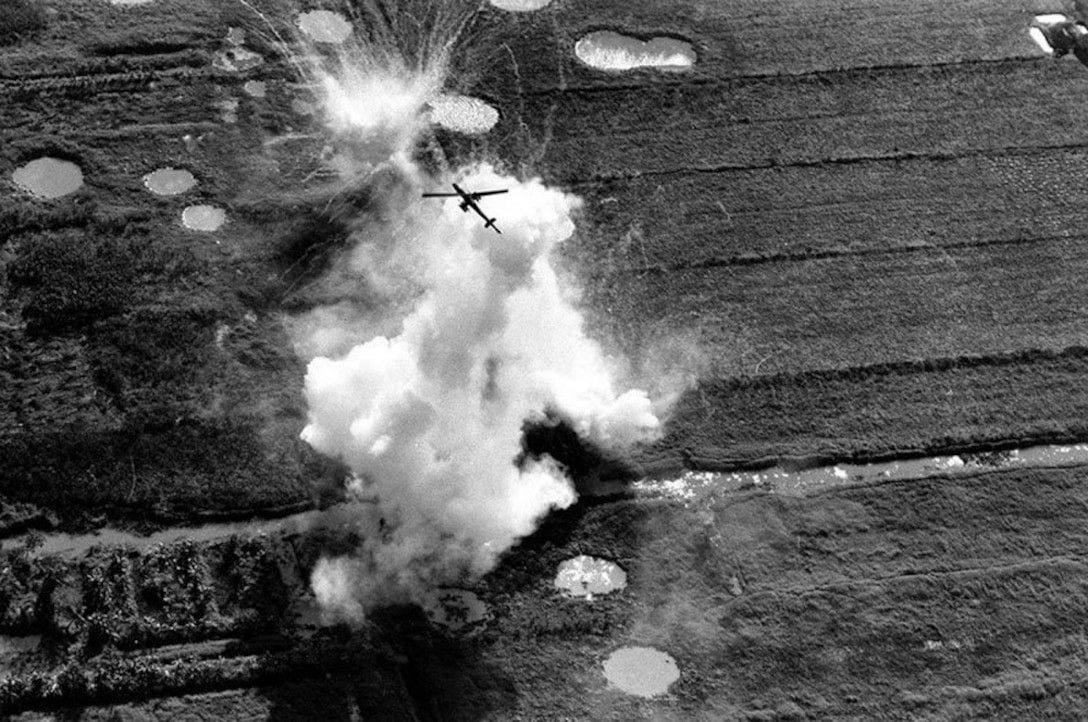 A UH-1E Gunship pulls out of a rocket and strafing attack on a Viet Cong position near Cao Lanh in the Mekong Delta, Jan. 22, 1969. Large craters caused by air and artillery strikes brought in on the area can be seen near the white explosion. (Courtesy photo from McInerney/AP)