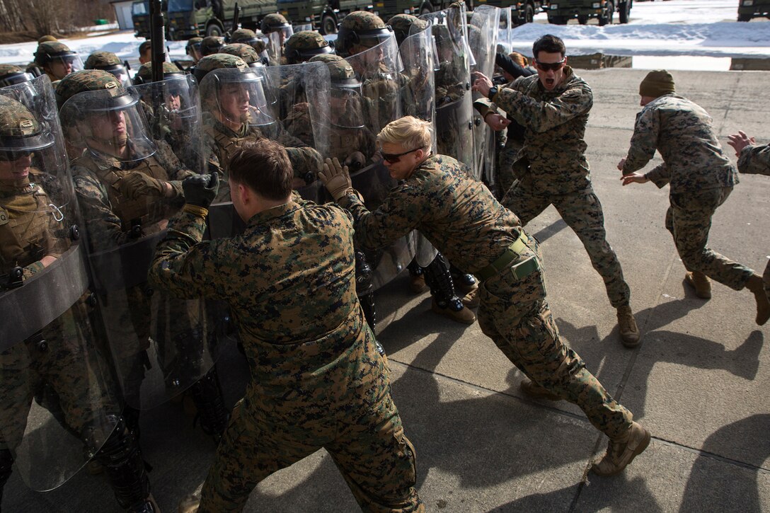 Marines with Marine Rotational Force-Europe 18.1 repel a simulated attack from their peers during non-lethal training at Vaernes Garnison, Norway, April 3, 2018. Dozens of Marines completed the riot control training, which added another level of proficiency to their combat skill set. The training will enable the unit to respond to potential threats throughout the region, strengthening strategic cooperation and partnership between the U.S. and its NATO Allies. (U.S. Marine Corps photo by Gunnery Sgt. Clinton Firstbrook)