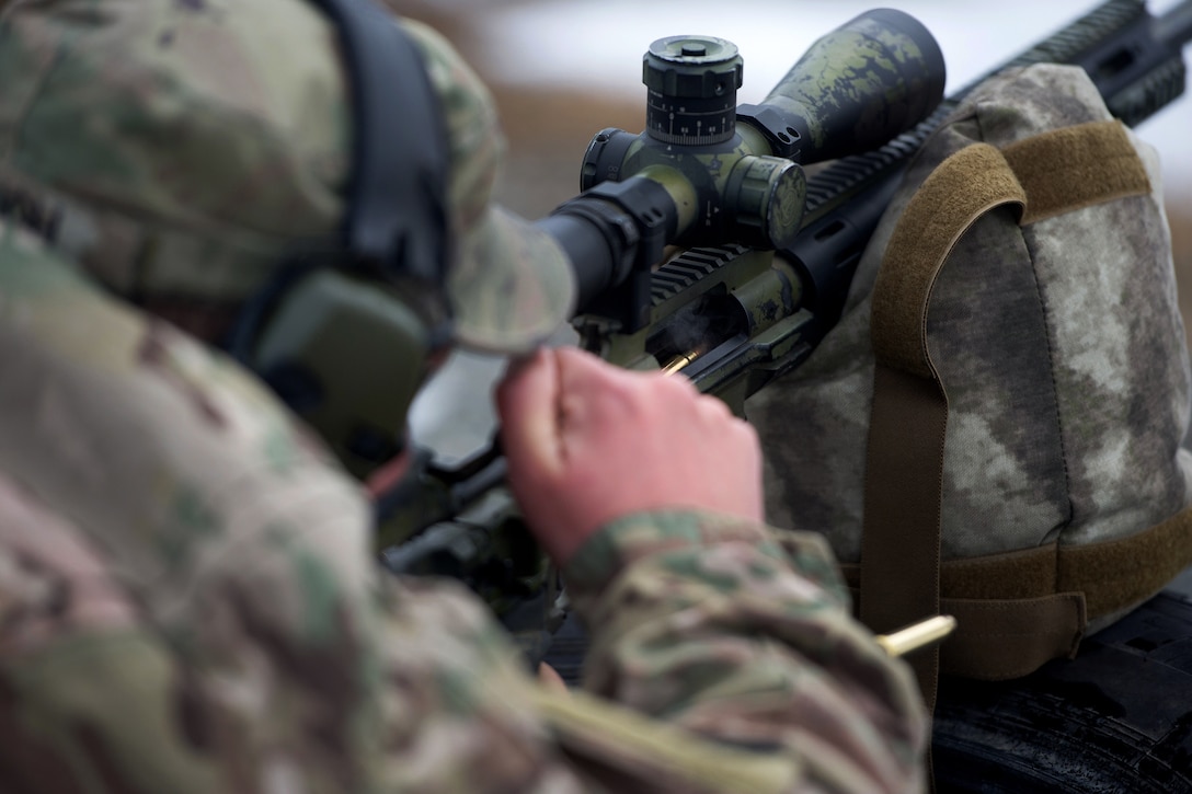 A soldier loads a round into his sniper rifle.