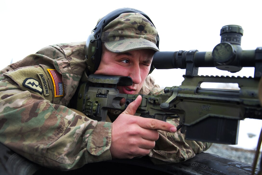 A soldier aims at a target with his sniper rifle.