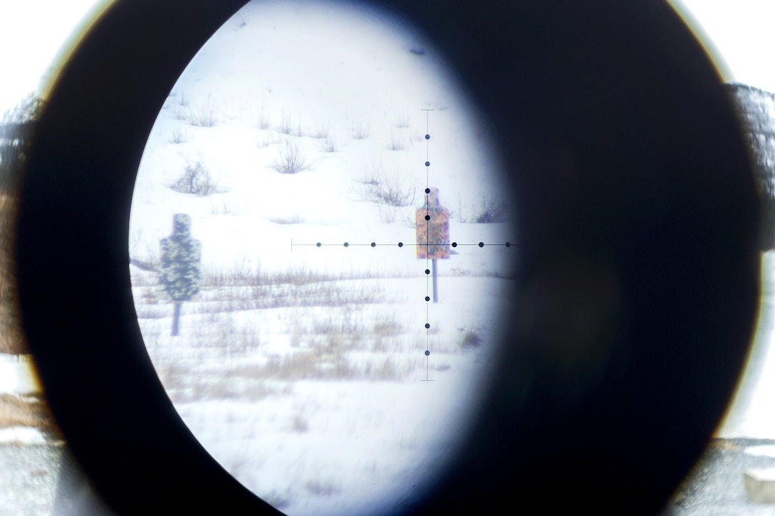 A soldier uses a spotting scope to view long-distance targets.