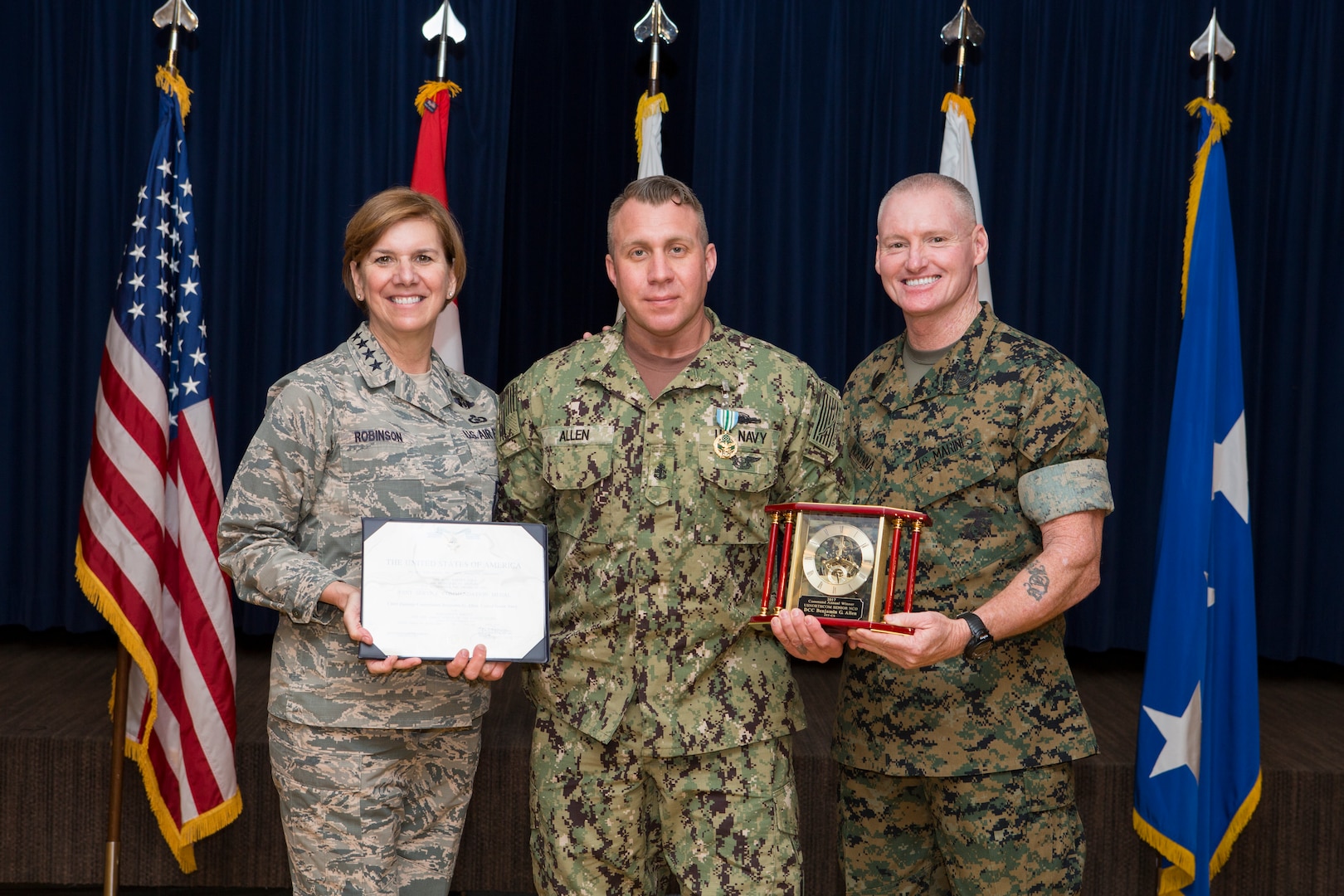 Chief Petty Officer Benjamin Allen, a senior non-commissioned officer at Joint Task Force Civil Support (JTF-CS), receives the Senior Non-Commissioned Officer (NCO) of the Year award from Air Force Gen. Lori Robinson and Marine Sgt. Maj. Paul McKenna at Peterson Air Force Base, Colo. Apr 4, 2018. To win this award, Allen competed against Senior NCOs from eight other units that fall under U.S, Northern Command. (Official DoD photo by Tech. Sgt. Joe Laws/released)