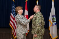 Chief Petty Officer Benjamin Allen, a senior non-commissioned officer at Joint Task Force Civil Support (JTF-CS), receives the Senior Non-Commissioned Officer (NCO) of the Year award from Air Force Gen. Lori Robinson and Marine Sgt. Maj. Paul McKenna at Peterson Air Force Base, Colo. Apr 4, 2018. To win this award, Allen competed against Senior NCOs from eight other units that fall under U.S, Northern Command. (Official DoD photo by Tech. Sgt. Joe Laws/released)