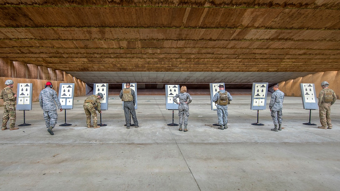 A row of airmen look at targets.