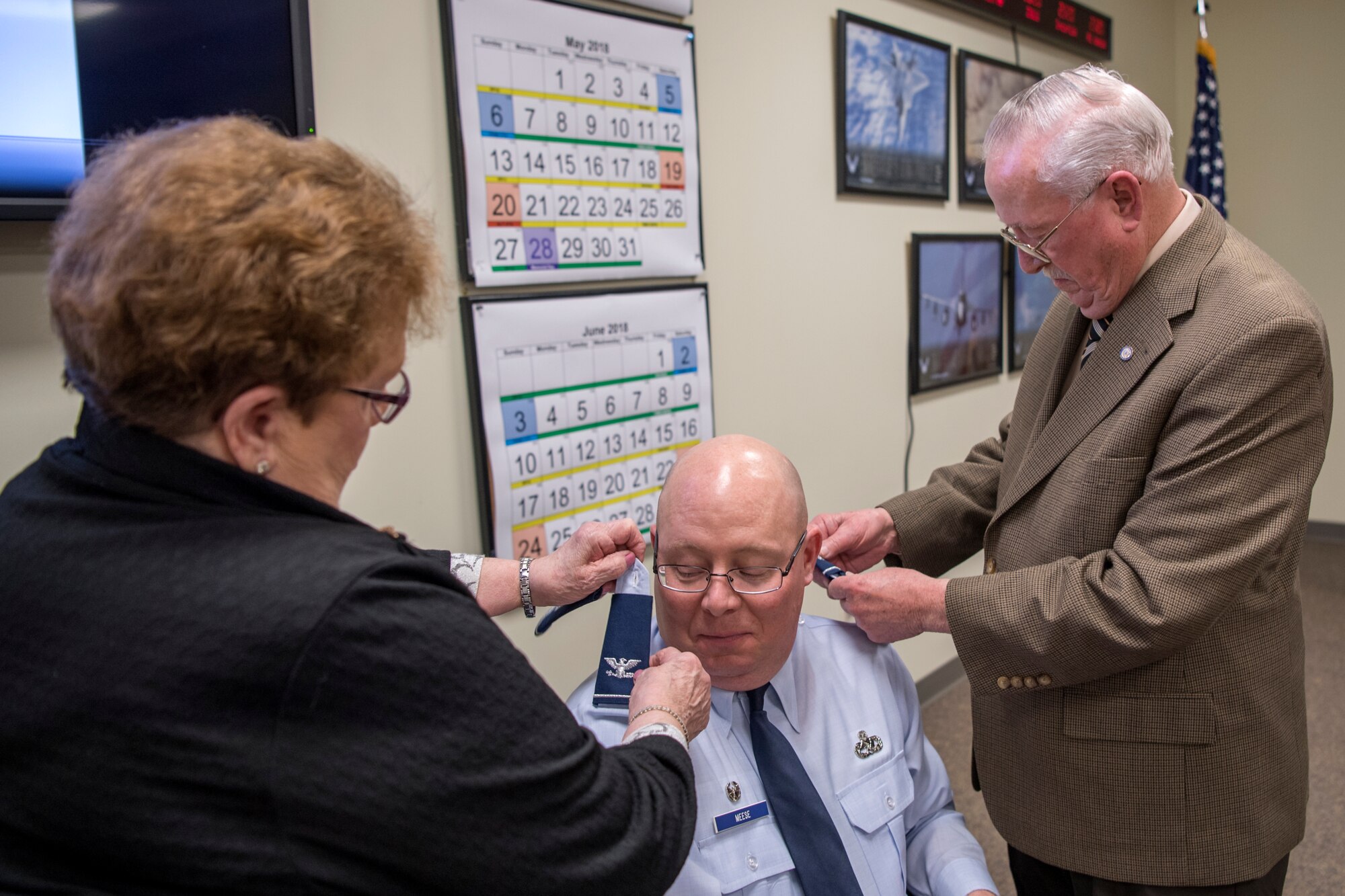 In the center, Col. Dwight Meese, 434th Maintenance Group commander, has his mother and father, Shirley and Ed Meese, add new shoulder boards bearing eagle rank insignias on his shirt during a pin-on ceremony at Grissom Air Reserve Base, Ind., April 7, 2018. Meese came to Grissom in 2017 from March Air Reserve Base, California, where he was deputy commander of the 452nd Maintenance Group. (U.S. Air Force photo/Tech. Sgt. Benjamin Mota)