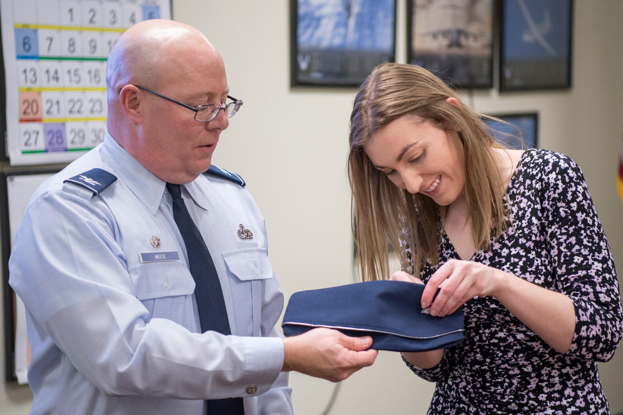 Col. Dwight Meese, 434th Maintenance Group commander, has Cindy Shamiyeh, a family friend, pin an eagle rank insignia on his flight cap during a pin-on ceremony at Grissom Air Reserve Base, Ind., April 7, 2018. Meese is among one percent of Air Force officers who make the rank of colonel during their military career. (U.S. Air Force photo/Tech. Sgt. Benjamin Mota)