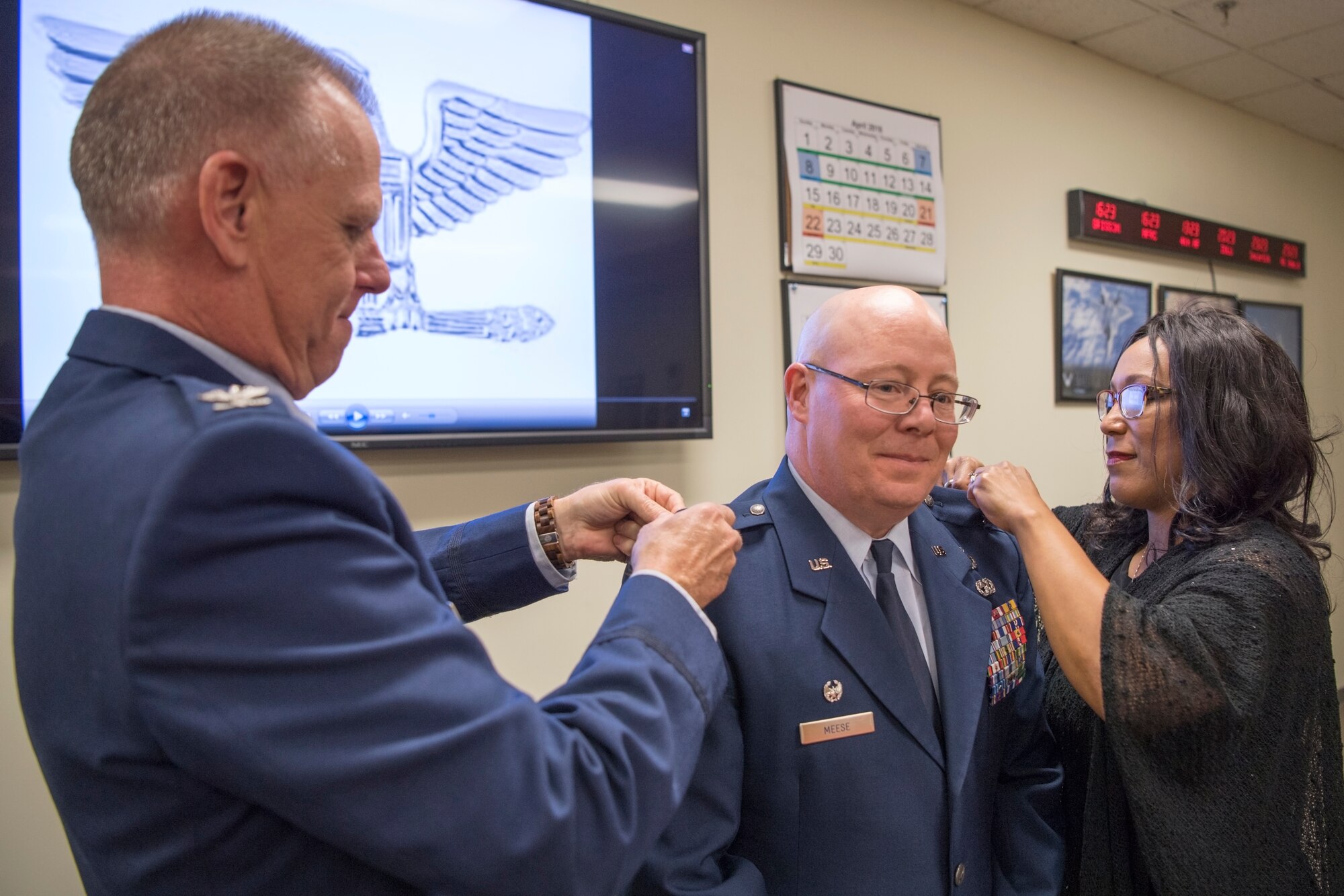 In the center, Col. Dwight Meese, 434th Maintenance Group commander, has Col. Larry Shaw, 434th Air Refueling Wing commander, left, and his wife Zie Meese, right, pin eagle rank insignias on his service dress coat during a pin-on ceremony at Grissom Air Reserve Base, Ind., April 7, 2018. Meese came to Grissom in 2017 from March Air Reserve Base, California, where he was deputy commander of the 452nd Maintenance Group. (U.S. Air Force photo/Tech. Sgt. Benjamin Mota)