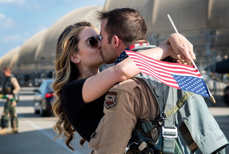 Capts. Laura and Bryan Watson, 4th Force Support Squadron operations officer and 336th Fighter Squadron pilot, kiss during a deployment homecoming, April 11, 2018, at Seymour Johnson Air Force Base, North Carolina.