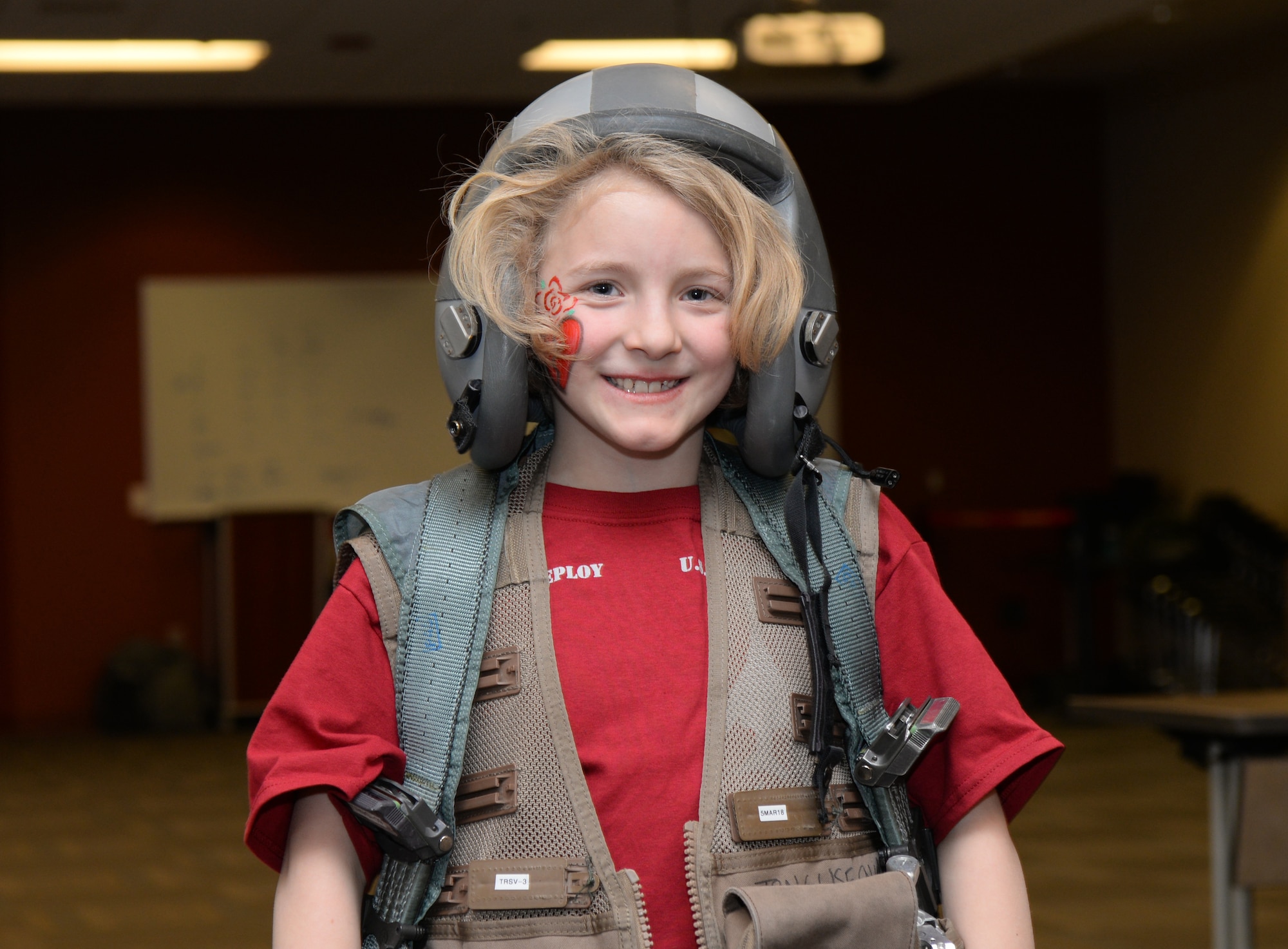 A child wears flight equipment during a kids deployment line at Ellsworth Air Force Base, S.D., April 7, 2018. The Month of the Military Child is celebrated in April to bring awareness to the important role the children of service members play in the armed forces community. (U.S. Air Force photo by Airman 1st Class Nicolas Z. Erwin)