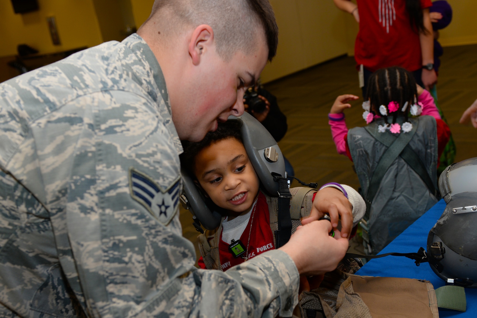 Senior Airman Cole Barnhart, a 28th Operations Support Squadron aircrew flight equipment technician, shows a child a compass during a kids deployment line at Ellsworth Air Force Base, S.D., April 7, 2018. Planning for this event took over three months of coordination with numerous base agencies. (U.S. Air Force photo by Airman 1st Class Nicolas Z. Erwin)