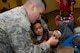 Senior Airman Cole Barnhart, a 28th Operations Support Squadron aircrew flight equipment technician, shows a child a compass during a kids deployment line at Ellsworth Air Force Base, S.D., April 7, 2018. Planning for this event took over three months of coordination with numerous base agencies. (U.S. Air Force photo by Airman 1st Class Nicolas Z. Erwin)