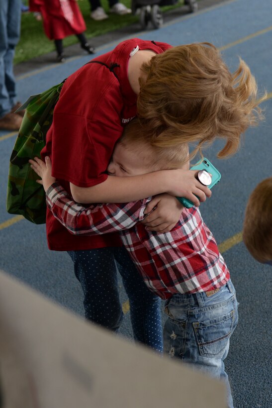 A child welcomes his sister back from a kids deployment line at Ellsworth Air Force Base, S.D., April 7, 2018. The groups of children were given 45 minutes to go through the deployment line, after which they were led back to the Pride Hangar where their families were waiting for them to return. (U.S. Air Force photo by Airman 1st Class Nicolas Z. Erwin)