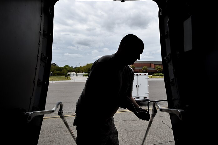 Staff Sgt. Travis Ryan, 437th Aircraft Maintenance Squadron scheduled maintenance NCO in charge, unscrews a panel on a C-17 Globemaster III at Joint Base Charleston, S.C., April 4, 2018.