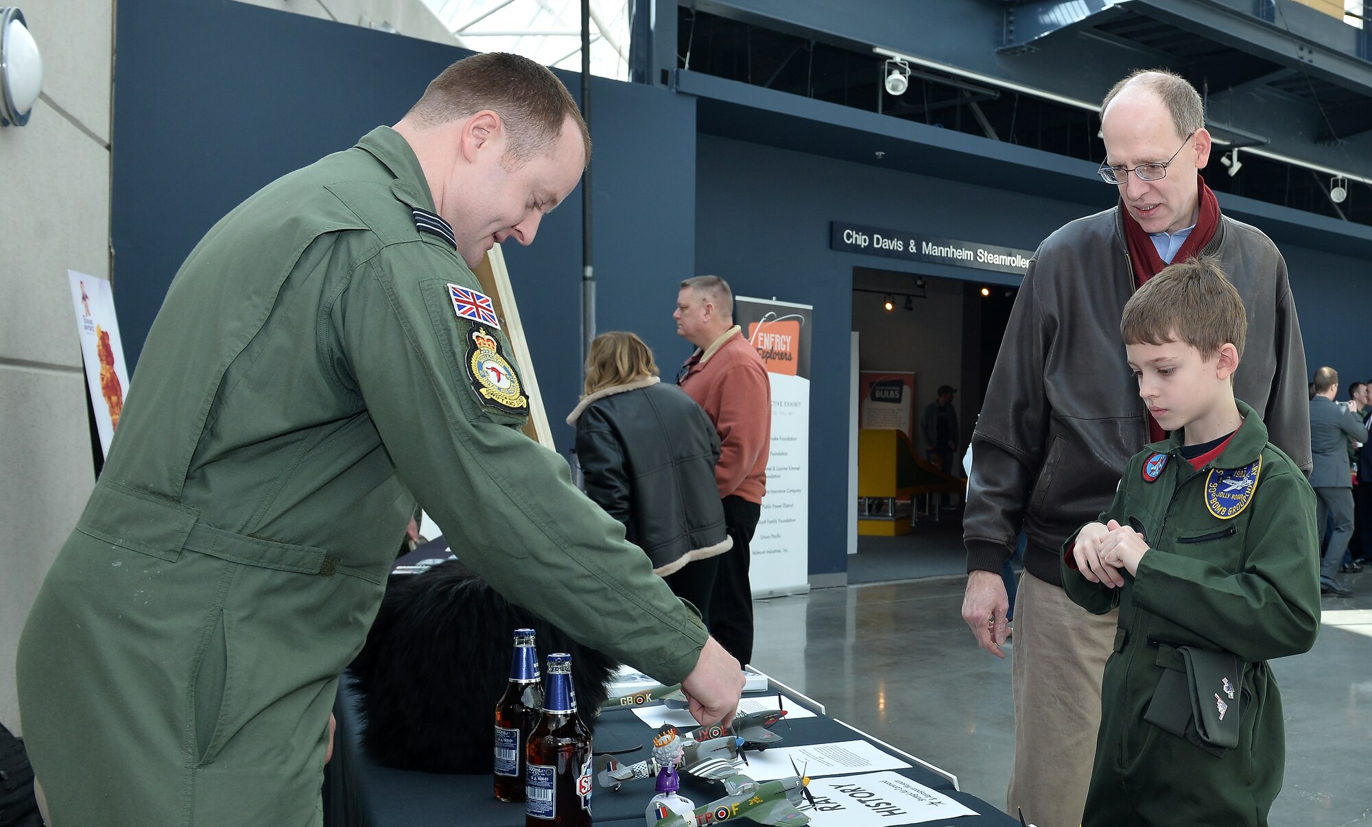 Royal Air Force Flight Lieutenant Gaz, with the 338th Combat Training Squadron, speaks to Bernie Victory and his son Paul about the model aircrafts on his display table while they are attending the War and Peace event commemorating the 70th anniversary of the U.S. Air Force and 100th anniversary of the U.K. Royal Air Force ceremony on April 7, 2018 inside the Strategic Air and Space Museum in Ashland, Nebraska.