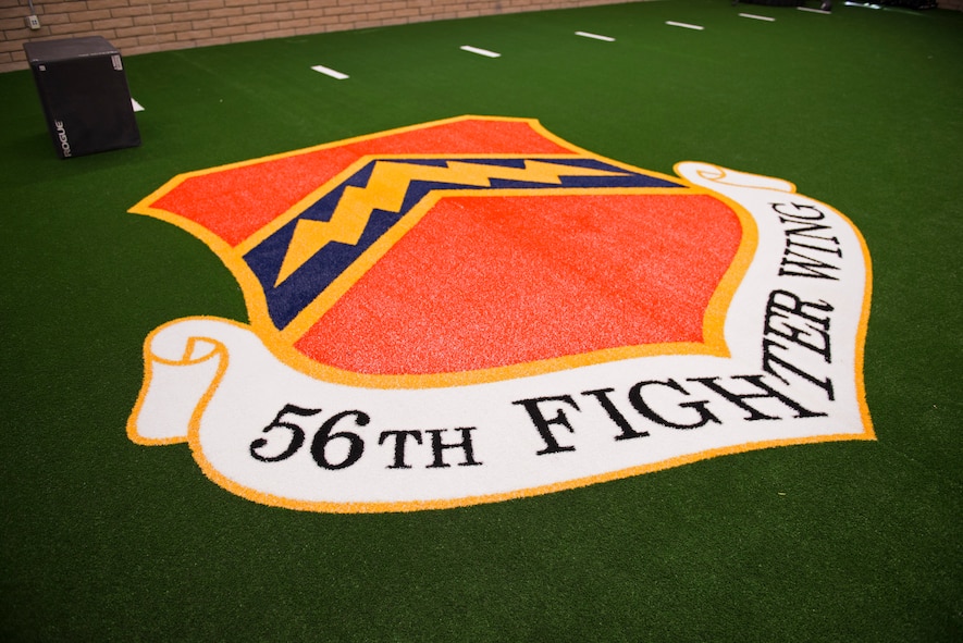 The 56th Fighter Wing insignia adorns the turf in the Tactical Integrated Training and Nutrition Arena April 9, 2018, at Luke Air Force Base, Ariz. The TITAN Arena will allow the professionals of the Human Performance Team to treat and develop fitness plans for pilots and other high-activity Airmen. (U.S. Air Force photo by Senior Airman Ridge Shan)