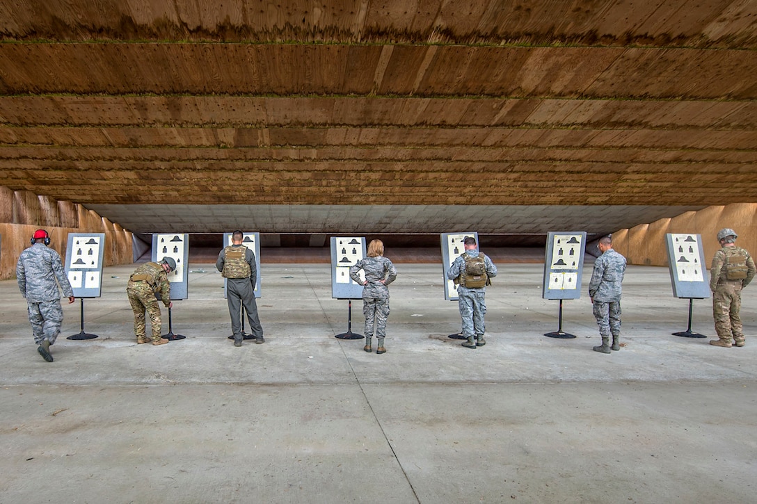 A row of airmen look at targets.