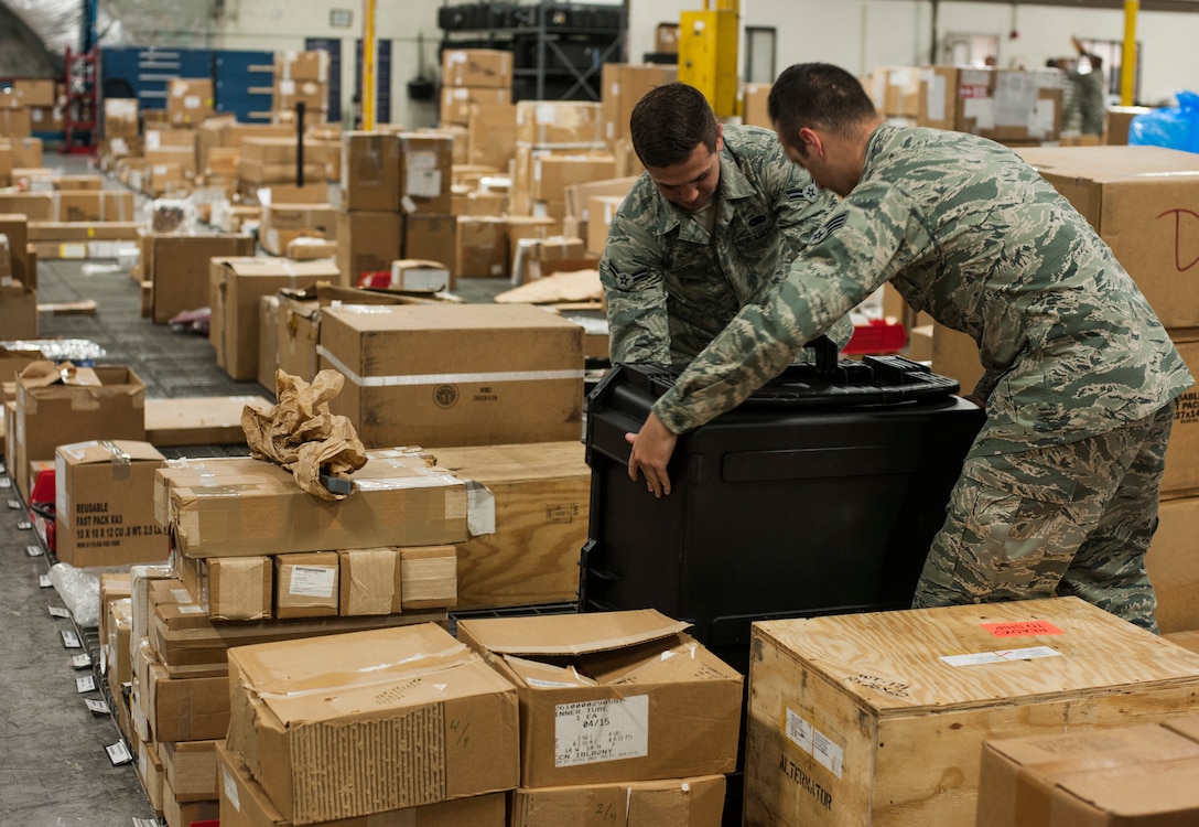 U.S. Air Force Airman 1st Class Justin Auger, a central storage technician, and Senior Airman Seth Soares, a flight service center technician, both assigned to the 6th Logistics Readiness Squadron, move a Pelican case at MacDill Air Force Base, Fla., April 11, 2018.