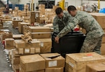 U.S. Air Force Airman 1st Class Justin Auger, a central storage technician, and Senior Airman Seth Soares, a flight service center technician, both assigned to the 6th Logistics Readiness Squadron, move a Pelican case at MacDill Air Force Base, Fla., April 11, 2018.