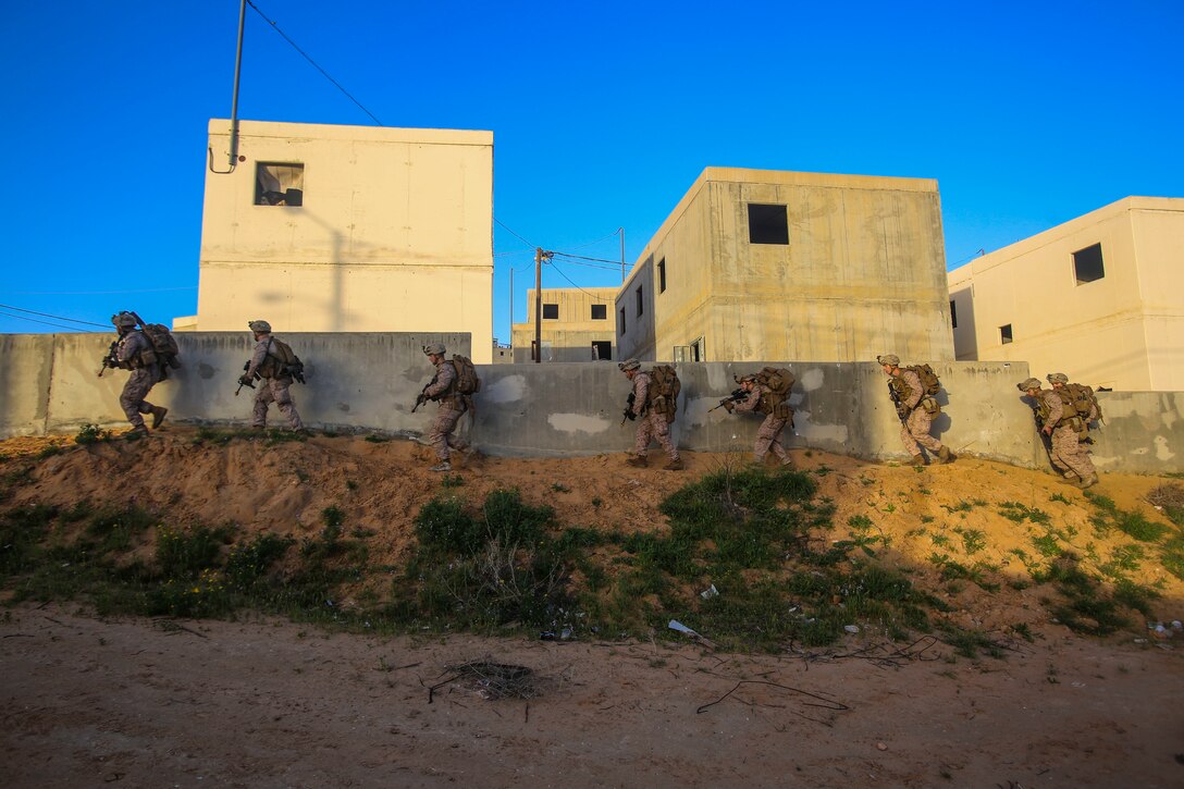 NATIONAL TRAINING CENTER, ISRAEL (March 13, 2018) U.S. Marines assigned to the Battalion Landing Team, 2nd Battalion, 6th Marine Regiment (BLT 2/6), 26th Marine Expeditionary Unit (MEU), maneuver around a building during exercise Juniper Cobra 2018 at the National Training Center in Israel, March 13, 2018. Juniper Cobra is a computer-assisted exercise conducted through computer simulations focused on improving combined missile defense capabilities and overall interoperability between the U.S. European Command and Israel Defense Force. (U.S. Marine Corps photo by Cpl. Jon Sosner/Released)