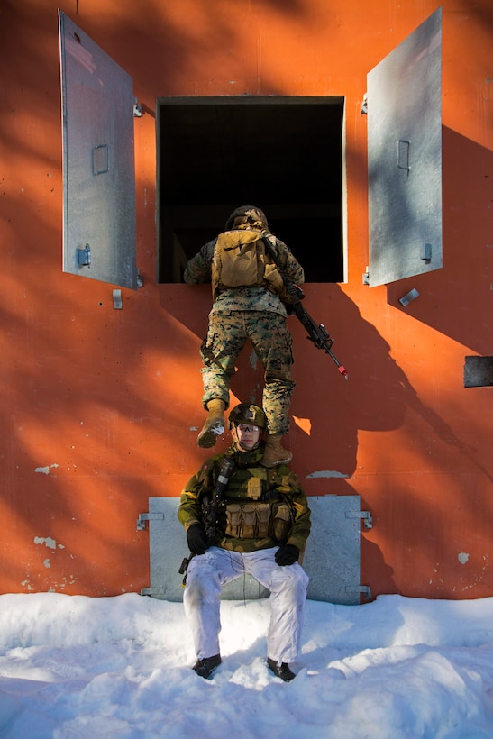 A Marine with Marine Rotational Force-Europe 18.1 climbs over a Norwegian soldier during close-quarters combat training at Leksdal Skytefelt Training Complex, Norway, March 27, 2018. The law enforcement Marines integrated with Norwegian Home Guard 12 to learn new breaching and clearing tactics. The event is one of many training evolutions the Marines plan to execute with their NATO Allies, enhancing strategic cooperation and partnership between the U.S. and Norway.