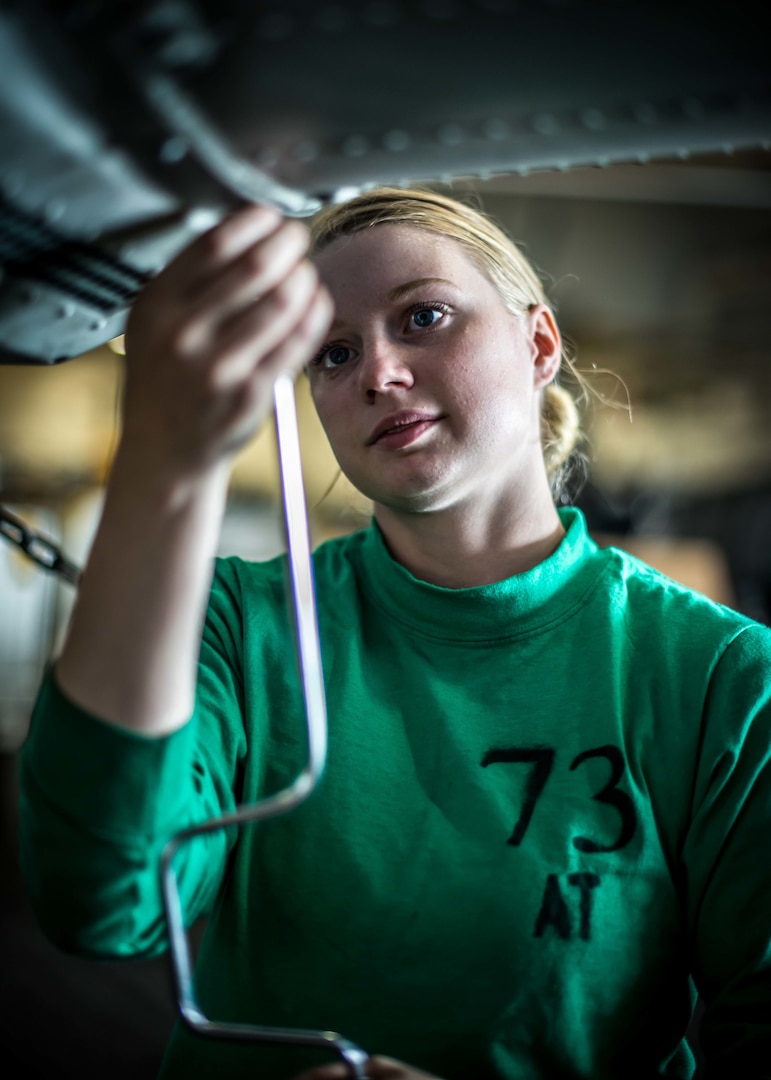 Aviation Electronics Technician assigned to Battlecats of Helicopter Maritime Strike Squadron 73 conducts maintenance on MH-60R Seahawk in hangar bay of USS Theodore Roosevelt, Pacific Ocean, April 24, 2017 (U.S. Navy/Bill Sanders)