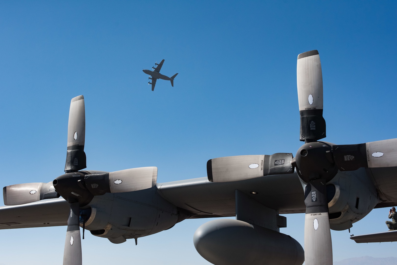 A Chilean Air Force C-130 flies above a Texas Air National Guard C-130 Hercules during the FIDAE 2018 international airshow in Santiago, Chile, April 8, 2018.  U.S. airmen participated in a variety of activities during the air show, including subject matter exchanges with the Chilean Air Force, aerial demonstrations, and interaction with the local community.  (U.S. Air Force photo by Staff Sgt. Danny Rangel)