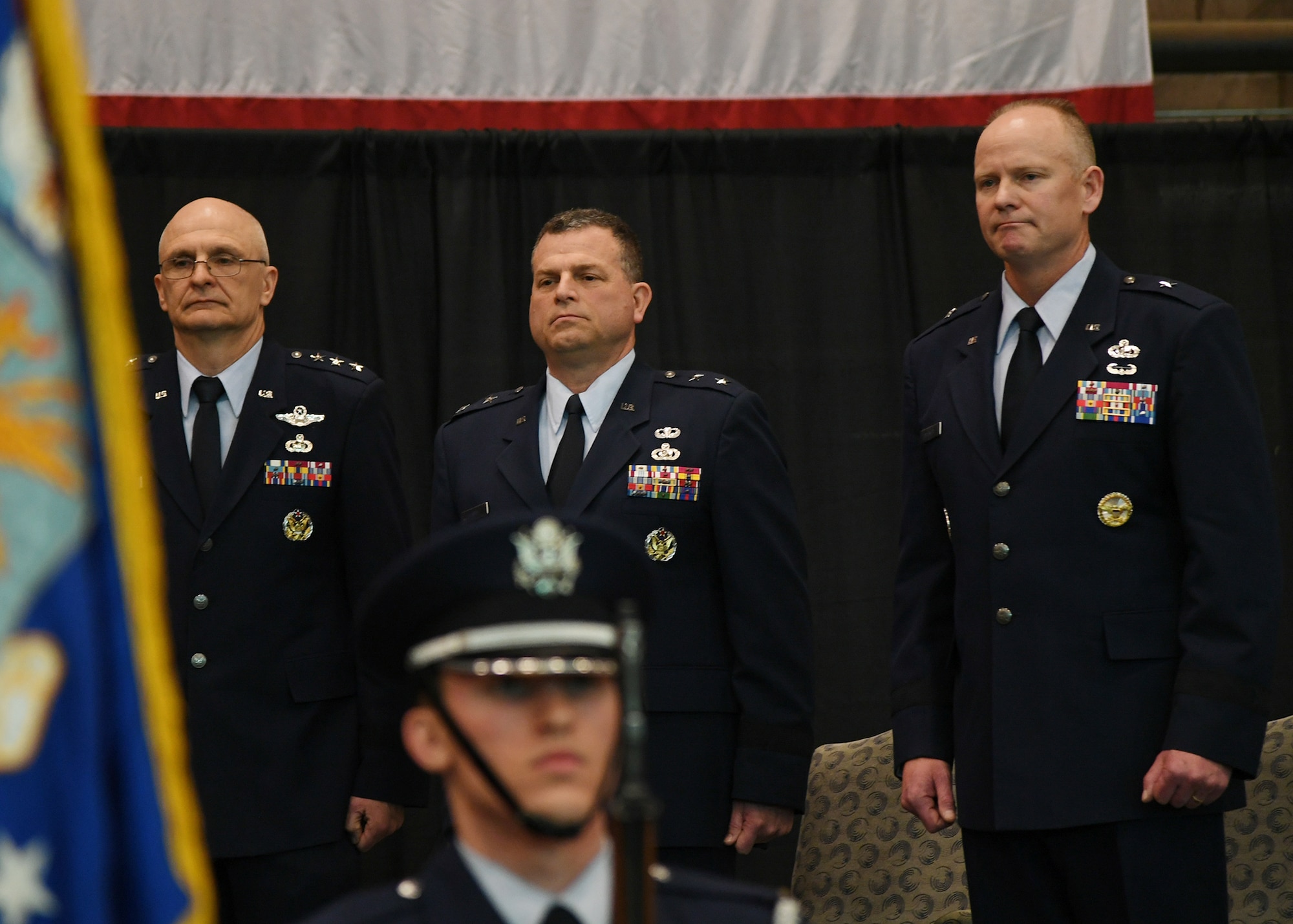 Brig. Gen. Michael Schmidt, right, takes leadership of the Command, Control, Communications, Intelligence and Networks directorate at Hanscom Air Force Base, Mass., April 13, 2018 from Maj. Gen. Dwyer Dennis, center, who is retiring, during a ceremony at hosted by Lt. Gen. Arnold Bunch, left, military deputy of the Office of Assistant Secretary of Air Force for Acquisition at the Pentagon. The change of leadership ceremony was held at the Hanscom Aero Club hangar.  (U.S. Air Force Photo by Linda LaBonte Britt)