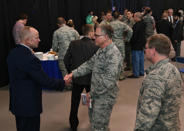 Brig. Gen. Michael Schmidt, left, greets Col. Richard McDermott, 66th Air Base Group Staff Judge Advocate, center, following his assumption of leadership of the Command, Control, Communications, Intelligence and Networks directorate at Hanscom Air Force Base, Mass., April 13, 2018 at the Hanscom Aero Club hangar. (U.S. Air Force Photo by Linda LaBonte Britt)