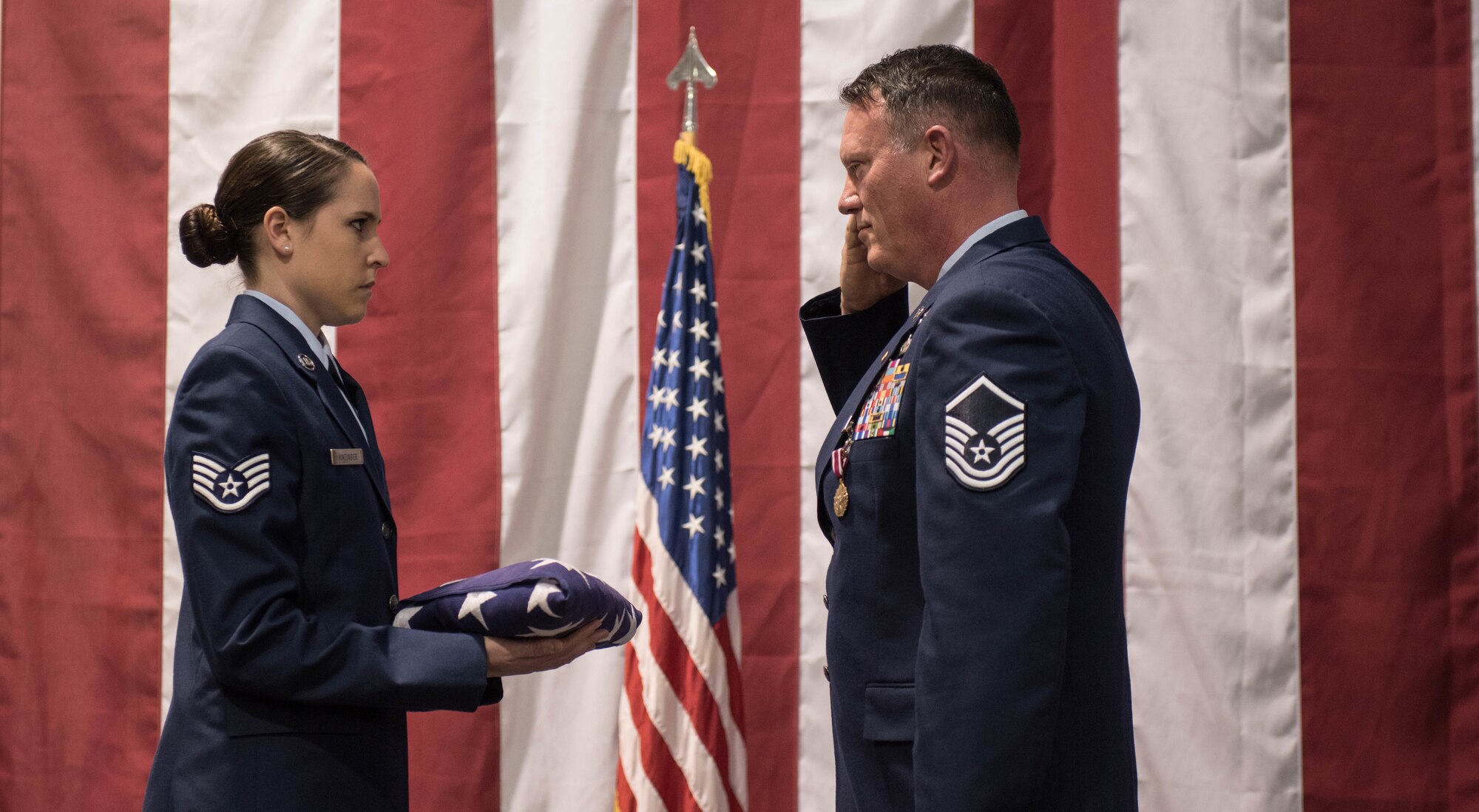 After 32 years of service, Master Sgt. Rodney Huffer, 921st Contingency Response Squadron, salutes an American Flag during a retirement ceremony at Travis Air Force Base, Calif. During Huffer career he has served on active duty, Air Force Reserves and the Air National Guard. (U.S. Air Force photo/Staff Sgt. Robert Hicks)