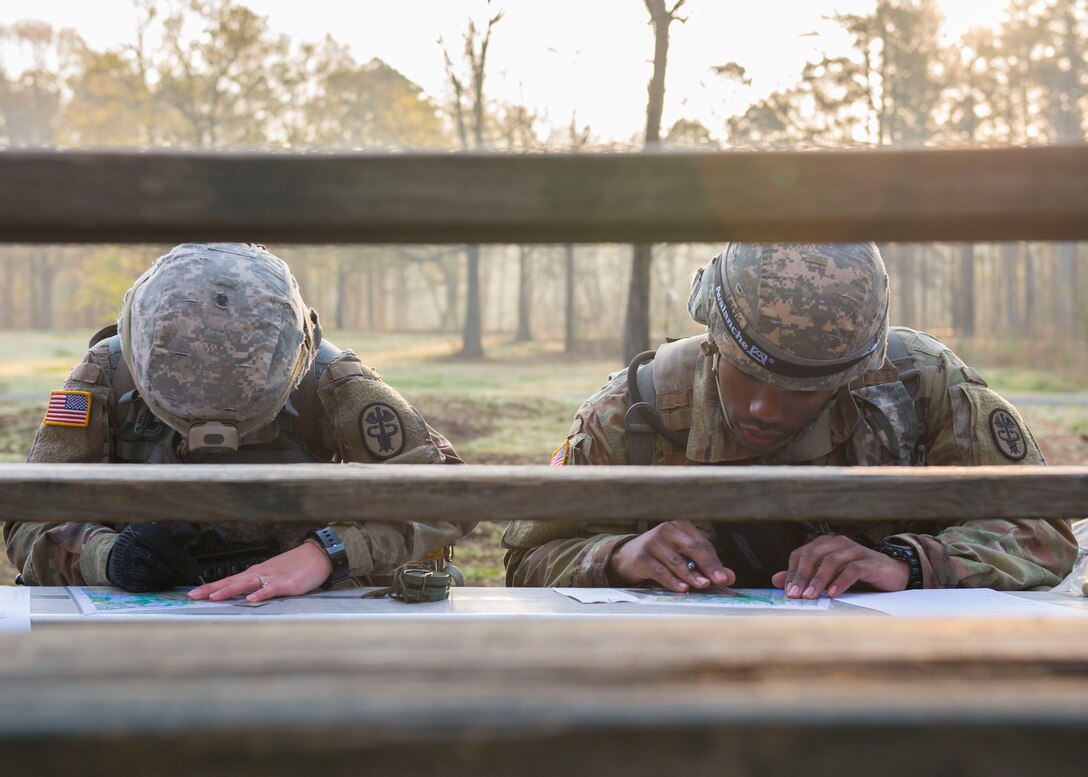 U.S. Army Spc. Natasha Shaw, Medical Department Activity optical lab specialist, and U.S. Army Sgt. Dequan Davis, MEDDAC patient administrator, study maps in Fort Eustis’ Training Area 23 at Joint Base Langley-Eustis, Virginia., April 11, 2018. The Soldiers were tasked with locating four designated points using only a map and compass in a land navigation exercise. (U.S. Air Force photo by Airman 1st Class Monica Roybal)