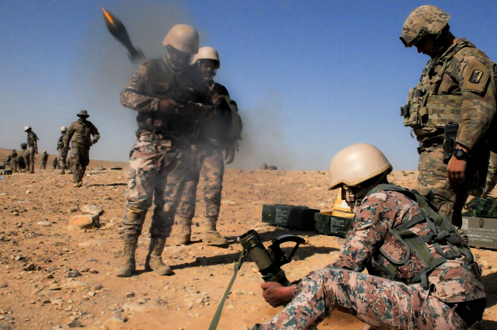 JOINT TRAINING CENER – (Right) U.S. Army Spc. Bradley Wilkerson, an indirect fire infantryman, 1st Battalion, 184th Infantry Regiment, trains alongside Jordan Armed Forces 11th Border Security soldiers during a 60 mm mortar live fire outside of Amman, Jordan, April 4, 2018.