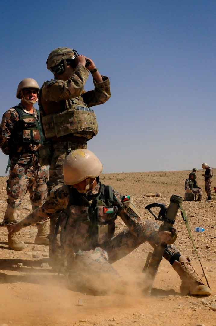 JOINT TRAINING CENER – (Middle) U.S. Army Spc. Mario Osorio, an indirect fire infantryman, 1st Battalion, 184th Infantry Regiment, observes a Jordan Armed Forces 11th Border Security soldier during a 60 mm mortar live fire outside of Amman, Jordan, April 4, 2018.